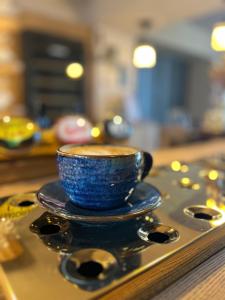 a blue cup on a saucer on a table at Colcombe Castle Hotel in Colyton