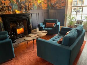 a living room with two blue couches and a fireplace at Colcombe Castle Hotel in Colyton