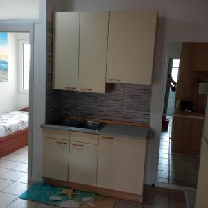 a kitchen with white cabinets and a sink at Dolce Relax - Sottomarina in Sottomarina +10 photos