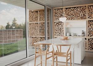 a kitchen with a table and chairs and a bunch of logs at La Petite Bûche #1 in La Malbaie