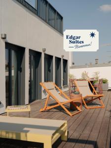 two lounge chairs on a deck next to a building at Edgar Suites Hameau - Porte de Versailles in Paris