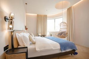 a bedroom with a bed with a chair and a window at EUPHORIA丨Quiet Garden Quiet Designer Garden Hotel丨Datang Never Sleeps City Big Wild Goose Pagoda Subway Station Branch丨Near the scenic area in Xi'an