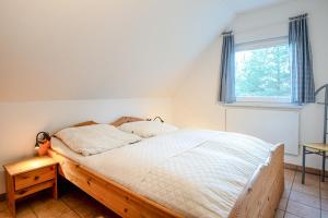 a bedroom with a wooden bed with a window at FH Seidenstücker in Breege