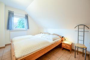 a bed in a room with a window and a ladder at FH Seidenstücker in Breege