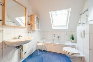 a bathroom with a sink and a toilet and a tub at FH Seidenstücker in Breege