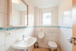 a white bathroom with a sink and a toilet at FH Seidenstücker in Breege +19 photos
