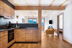 a kitchen with wooden cabinets and a living room at Gantershof in Titisee-Neustadt