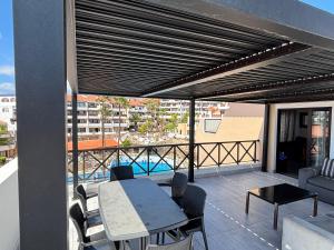Un patio con una mesa y sillas en un balcón. en Golf del Sur Parque Albatros 417, en San Miguel de Abona