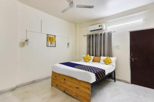 a bedroom with a bed with yellow and blue pillows at SPOT ON Hotel Blue Moon in Nagpur +25 photos