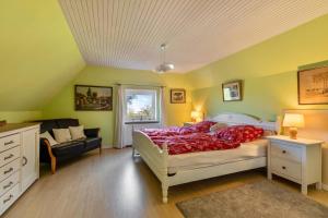 a bedroom with a bed and a couch at Ferienhaus Busch in Elpersbüttel