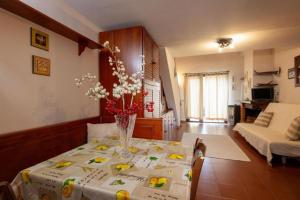 un salon avec une table avec un vase de fleurs dessus dans l'établissement Dimora Annilor Castel di Sangro, à Castel di Sangro 13 autres photos