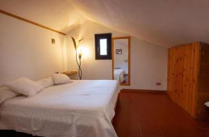 une chambre avec un lit blanc et un miroir dans l'établissement Dimora Annilor Castel di Sangro, à Castel di Sangro