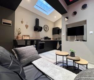un soggiorno con un divano e una TV di Le Temple du Désir - Intimité & plaisir - HyperCentre a Rouen