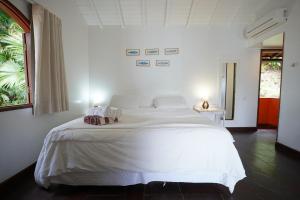 a bedroom with a large white bed with towels on it at Casa da Ilha & SPA in Abraão