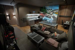 Luxury Villa Orion with heated Pool, Billard في Biéville-Beuville: غرفة معيشة مع أريكة وسيارة على الحائط