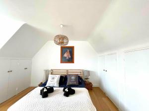 a bedroom with a bed with black pillows on it at Ty Glou Maison Charmante - 5m plage in Ploemeur