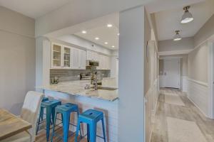 a kitchen with blue stools at a counter at Ocean Club 1208 by Wild Dunes, Oceanfront in Isle of Palms