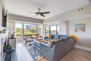 a living room with a blue couch and a ceiling fan at Ocean Club 1208 by Wild Dunes, Oceanfront in Isle of Palms +25 photos