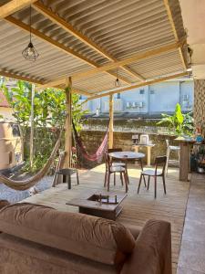 a living room with a couch and a hammock at Hostel São Lourenço in Bertioga +14 photos