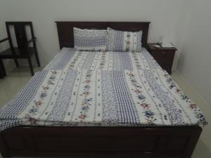 a bed with a blue and white quilt on it at Ngan Ha Hotel in Can Tho