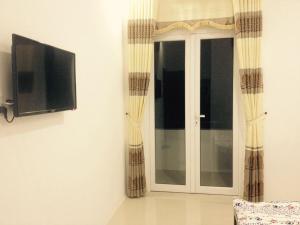 a sliding glass door with a television on a wall at Ngan Ha Hotel in Can Tho