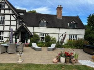 a house with a patio in front of it at The Retreat in Spetchley