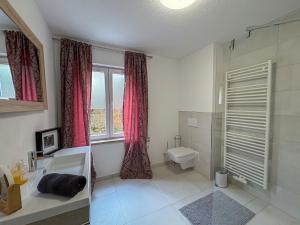 a bathroom with a tub and a toilet and a window at Villa Amselgrund in Rathen +70 photos