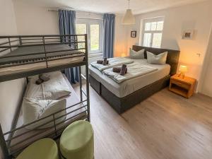 a bedroom with two bunk beds and a desk at Villa Amselgrund in Rathen