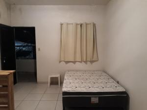 a bedroom with a bed in a room with a window at Flats Encantador in Rio das Ostras +3 photos