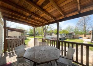 een terras met een tafel en stoelen op een dek bij Del Falco AgriCamp-12 kilometers to Garda Lake and Verona in Bussolengo