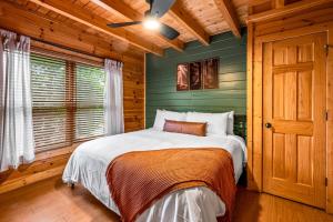 a bed in a bedroom with a green wall at Smoky Haven Retreat By Beyond Expectations in Pigeon Forge +54 photos