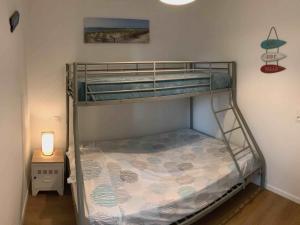a bunk bed in a room with a lamp on a table at Maison charmante à Mimizan Plage pour 5 pers, proche océan et commerces - FR-1-50-115 in Mimizan