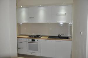 a kitchen with white cabinets and a sink at Apartment Sea San in Makarska
