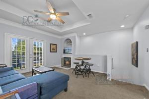 a living room with a blue couch and a ceiling fan at Legacy Villa 504 in Gulfport