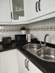 a kitchen with a sink and a microwave at Casa Lucía - Caminito del rey in Valle de Abdalagís