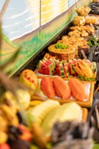 a buffet of food with fruits and vegetables on trays at Pousada Ponta de Mangue in Maragogi
