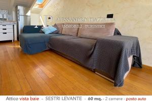 un sofá sentado en una sala de estar en una habitación en Attico Vista Baie, en Sestri Levante