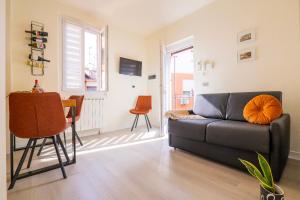 a living room with a black couch and a table at Casa Barabba - Appartamento Azzurro in Omegna