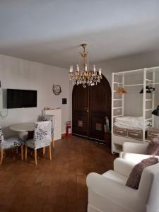 a living room with a dining table and a chandelier at Suite "La Finestra su Alghero" in Alghero