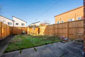 a backyard with a wooden fence and a building at Sunset Suite - Coop LIVE - Etihad - Pool Table in Manchester