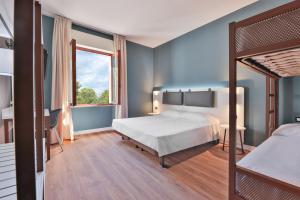 Marina di Campo AirportElba Vibe Smart Hotel的带床和窗户的卧室