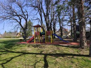 a playground with a slide in a park at Pine & Peak Zlatibor Apartman in Zlatibor