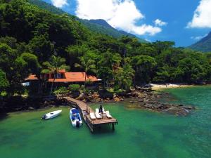 a dock with a boat and a boat on the water at Casa da Ilha & SPA in Abraão