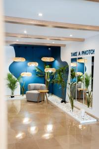 a lobby with a blue wall with a couch and plants at Carvi Beach Hotel in Lagos