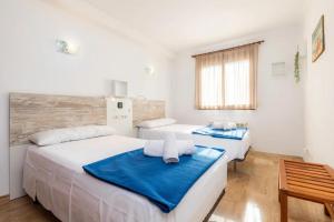 sypialnia z dwoma łóżkami i oknem w obiekcie Sa Coromina & Sa Estany Apartments - 1 min to Beach and Restaurants w Cala Ratjada