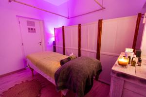 a bedroom with a bed with purple lights on it at O Quintal Guesthouse in Carvoeiro
