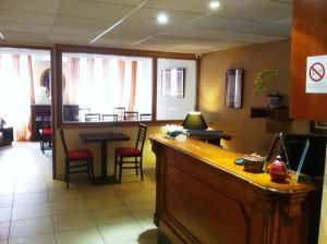a bar in a waiting room with a table and chairs at Hôtel du Sud Vieux Port in Marseille