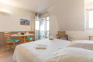a bedroom with a bed and a table and chairs at Résidence Pierre & Vacances Les Tamaris in Trouville-sur-Mer