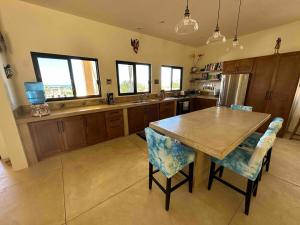 a large kitchen with a wooden table and chairs at Casa Corazon - Private Home w Mtn & Ocean Views! in El Pescadero