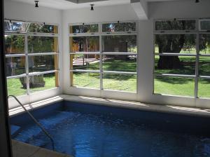 a swimming pool in a room with windows at Hotel Parque in Merlo +13 photos